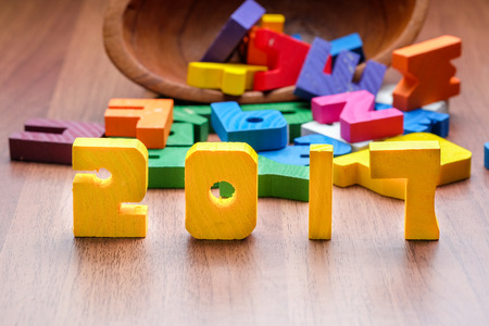 2017 new year number yellow color toy on wood table with other font toy, Holiday concept.