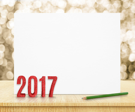 new year 2017 red glitter (3d rendering) on white poster on wood table at gold sparkling bokeh background,Leave space for display or montage of your design,Holiday greeting card.の写真素材
