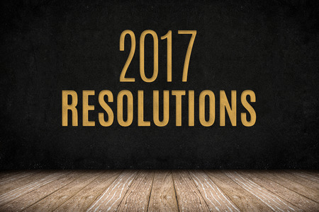 2017 resolutions gold text on blackboard wall on wood plank floor,New year business planing.