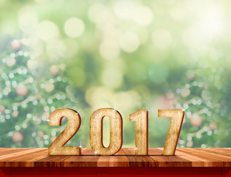new year 2017 text (3d rendering) on wood plank table with blur Christmas tree green background,Holiday greeting cardの写真素材