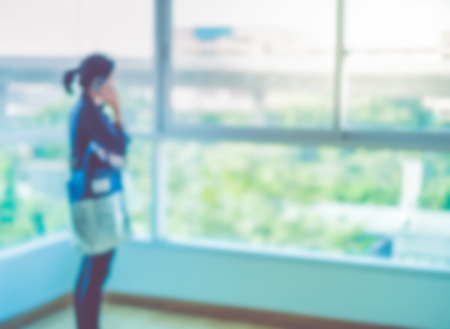 Blurred background ,woman talk on phone at condominium room.の写真素材