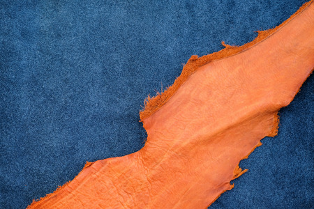 Close up orange rough edge and navy blue leather divide in two section, fashion texture background,fabric division.の写真素材