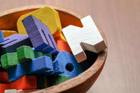 Close up alphabet toy in wood bowl on wood table top.の写真素材