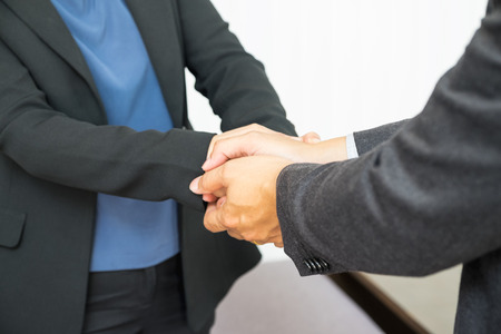Close up businessman use two hand holding businesswoman hand for Congratulations about success of plan.の写真素材