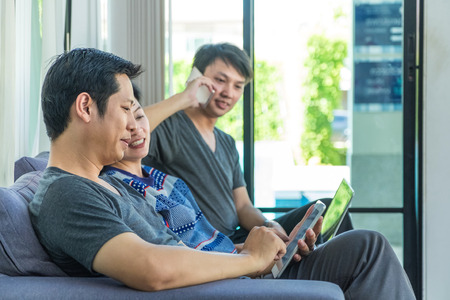 Group of people discussion by using mobile phone,tablet ,laptop computer at home,casual meeting,mobile office.の写真素材