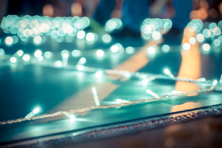 Blurred background,low angle view of people walk at night event fair with bokeh light.