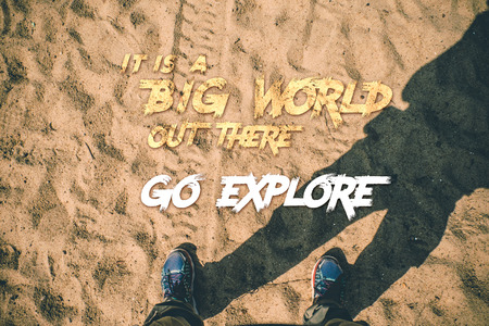 Inspiration Motivation quote,It is a big world out there,Go explore word with aerial feet stand on sand with tire tracks.Motivational typographicの写真素材