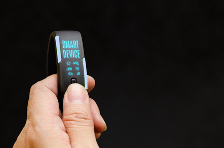 Close up hand holding smart watch to control feature with blank black background,Smart device...