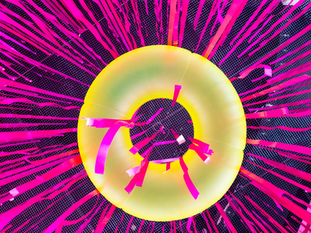 looking up at yellow swimming ring with vivid pink party ribbon,abstract background.