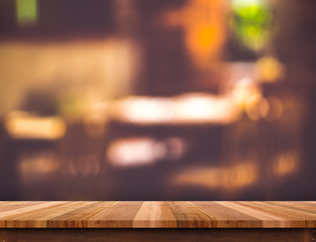 Empty brown wooden table and blurred restaurant bokeh light background. Mock up for display or montage of product,Business presentation.の写真素材