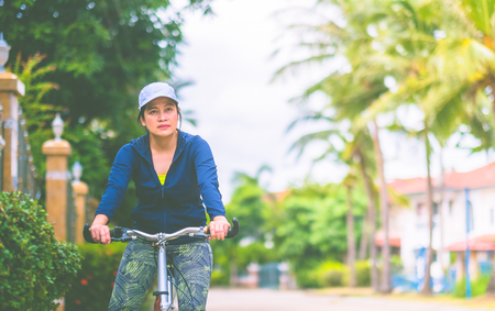 Woman with gym suit ride bike for exercise in village garden in morning time,Healthy lifestyle.の写真素材