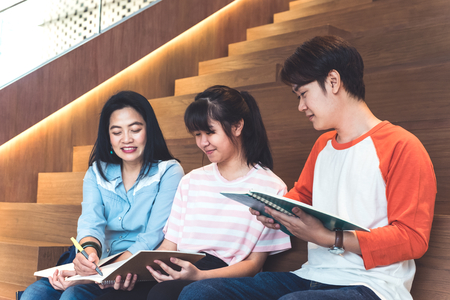 Groups of asian teenage students studying together at university stair library.の写真素材
