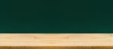 Empty long wood table top with green blackboard at background,Mockup template for adding or display of product,Education concept.の写真素材