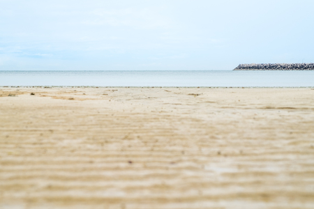Close up beach sand with blur sea at background.の写真素材