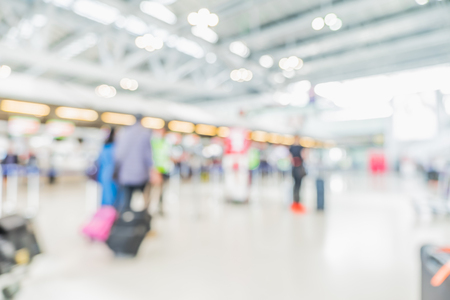 Blurred background,Traveler with baggage at Terminal Departure Check-in at airport with bokeh light.の写真素材