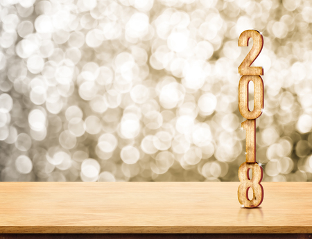 2018 new year wood number (3d rendering) on wood table with sparkling gold bokeh wall,leave space for display or montage of productの写真素材