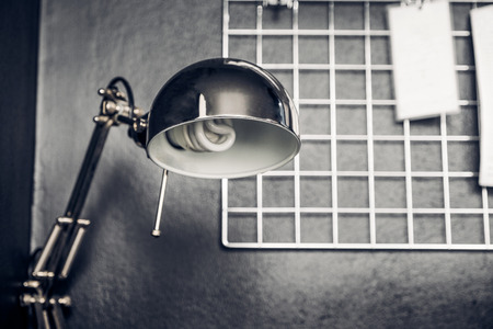 Office desk with metal lamp with black wall and note paper,workplace.の写真素材
