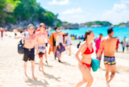 Blurry abstract background of tourist walking on beach and sea shore with mountain at sunny day,summer vacation concept.の写真素材