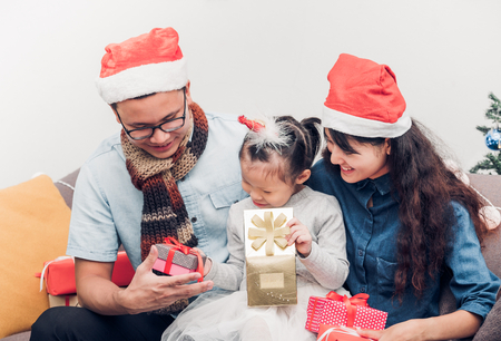 Happy family Asia family wear santa claus hat exchange Christmas gift box at house xmas party,Holiday celebrating festive concept,vintage filterの写真素材