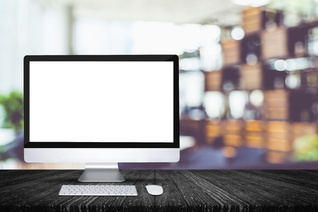 Blank screen desktop computer on black plank wooden table top with blur restaurant bokeh background,Mock up for display or montage of design.の写真素材