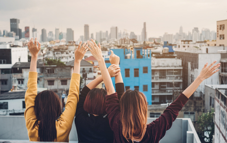 Happy group of asia girl friends enjoy and arm up relax pose at roof top party at evening sunset,Holiday celebration festive,teenage lifestyle,freedom and funの写真素材