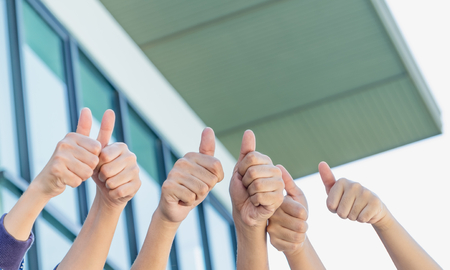 close up group of hand thumbs up at office building,good success business conceptの写真素材