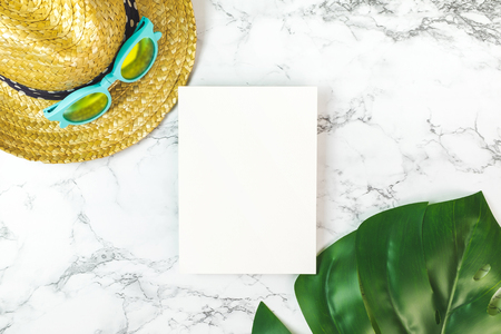 Blank white paper card on marble table top view with summer beach accessories monstera leaves ,Summer vacation concept,Mock up template for adding your design or text.の写真素材