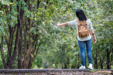Asian woman backpacker standing on countryside road with tree in spring seasonal,Alone travel or single traveller concept.の写真素材