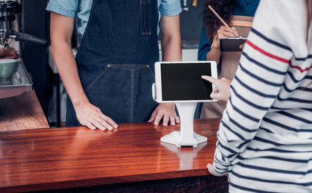 customer self service order drink menu with tablet screen at cafe counter bar,seller coffee shop accept payment by mobile.digital lifestyle concept.Blank space for display of design.の写真素材
