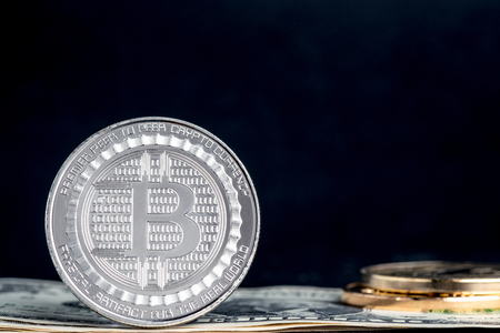 crypto currency Silver and gold bitcoin on dollar banknote on black table,Virtual digital money concept.financial businessの写真素材