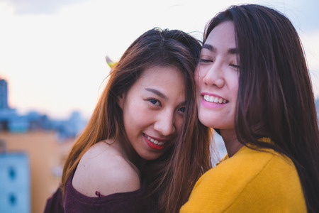 Two asia lesbian lgbt couple at roof top party in sunset evening time,love wins concept,enjoy and cheerful lifestyleの写真素材
