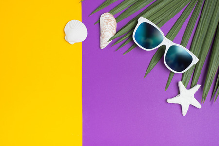 Set of summer object sunglasses sky reflect, star fish,shell and palm leaf on vivid yellow purple background.Holiday vacation backdrop.Copy space for display of product or content designの写真素材