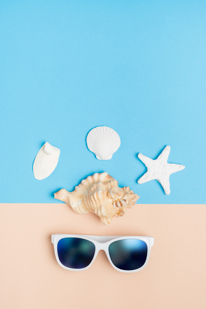 Set of summer object sunglasses,shell,starfish on pastel beige and blue background vertical.Holiday vacation backdrop.Copy space for display of product or content designの写真素材