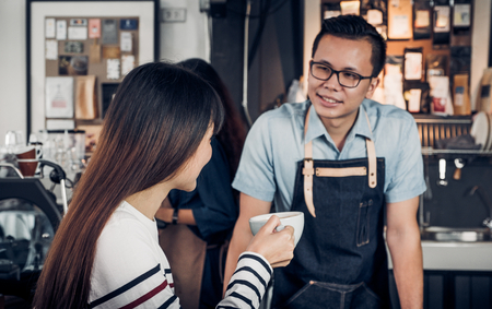 Male barista talking with customer about tasted of coffee cup with happy emotion at counter bar at cafe.coffee shop business owner concept,Service mind waiterの写真素材