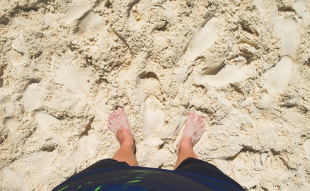 aerial view of barefoot with swimming suit stand on sand at sea beach in sunny day,summer vacation holiday lifestyle.Leave space on top for adding your textの写真素材