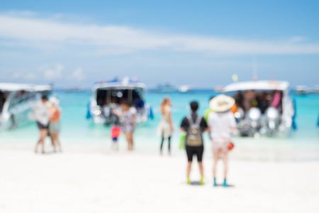 Blurry abstract background of tourist walking on beach and sea shore with mountain at sunny day,summer vacation conceptの写真素材