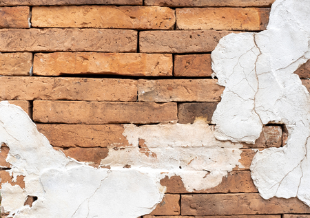 Grunge orange brick wall with crack white cement plaster texture background,outdoor wallの写真素材