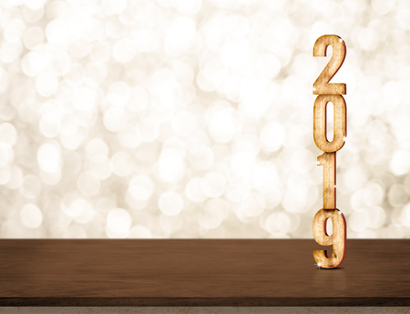 Happy New Year 2019 gold glossy with sparkling star on dark brown table with gold bokeh wall,Holiday festive celebration concept.copy space for display of text or contentの写真素材