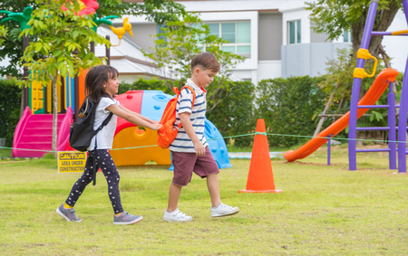 Two kid school children walking at playground in kindergarten preschool.back to schoolの写真素材