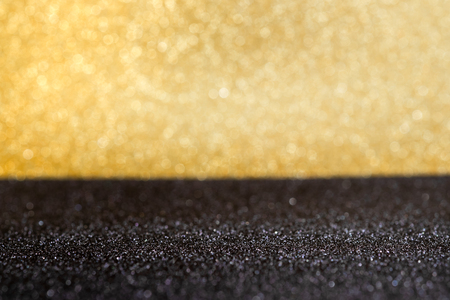 Abstract gold and black sparkling bokeh wall and floor background studio.luxury holiday backdrop mock up for display of product or content.festive greeting cardの写真素材