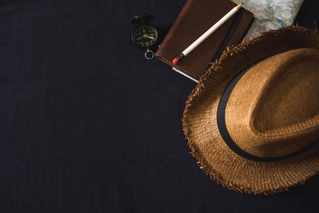 Top view of Summer brown panama straw hat,notebook map,compass on linen navy blue cloth.vacation travel concept.copy space for adding textの写真素材