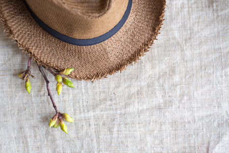 Top view of Summer brown panama straw hat with flower plant on linen cloth.travel concept.copy space for adding textの写真素材