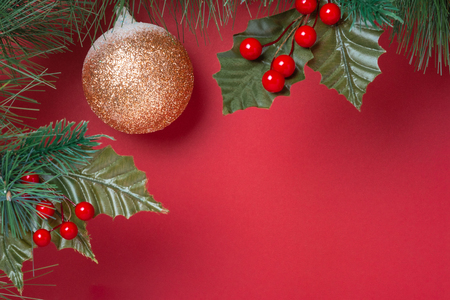 Christmas decoration and fir branches wreath with cherry and pine cone on red table background. winter holiday festive celebration concept.copy space for greeting cardの写真素材