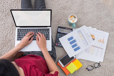 Top view asian woman freelance working on laptop with paperwork at home,work at home concept.mock up screenの写真素材