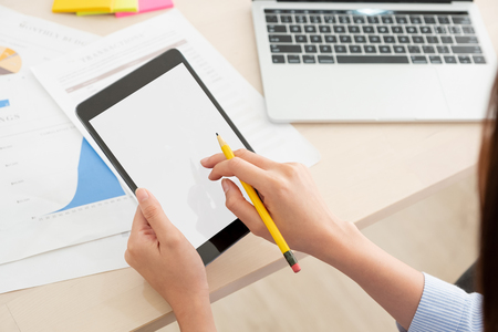 Shoulder view of woman use tablet and  laptop working online on table at home.mock up template device screen.の写真素材
