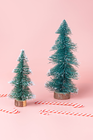 Tree Christmas tree with candy cane on pastel pink studio background.Holiday festive celebration greeting card with copy spaceの写真素材