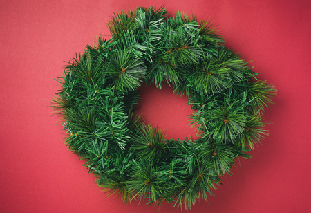 Merry christmas wreath on red wall background.copy space for adding text or design.Celebration holiday festive greeing cardの写真素材