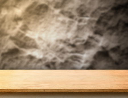 wooden plank table top at blurred rough stone wall,Template mock up for display or montage of productの写真素材