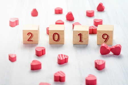 2019 new year on wood cube with group of mini red heart on white rustic table top,Holiday conceptの写真素材