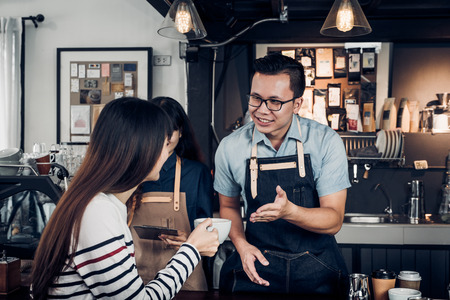 Male barista talking with customer about tasted of coffee cup with happy emotion at counter bar at cafe.coffee shop business owner concept,Service mind waiterの写真素材